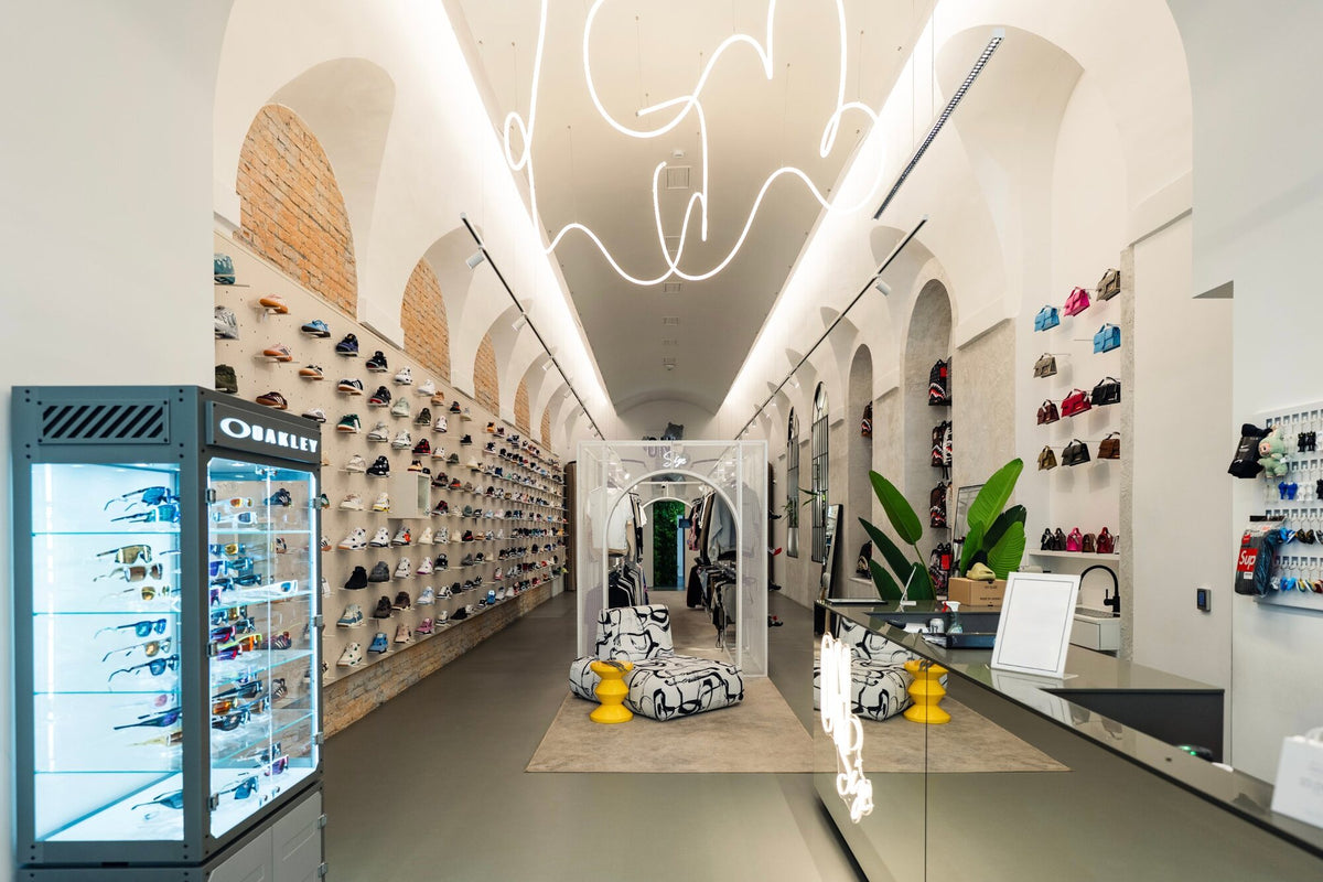 Az üzlet hosszú, boltíves tere sneakerfalakkal és pihenősarokkal